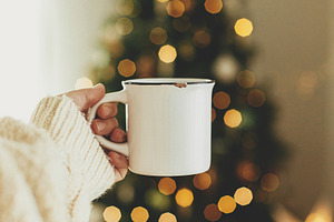 Hand holding stylish white cup against stylish festive christmas, a Holiday Photo by Sonjachni