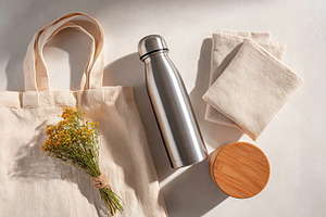 Stylish reusable items for sustainable living featuring a water bottle and tote, a Photo by AlyaAnd