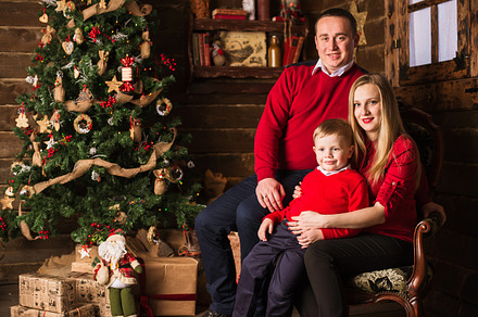 Young pregnant mother, father and small son celebrating Christmas at home