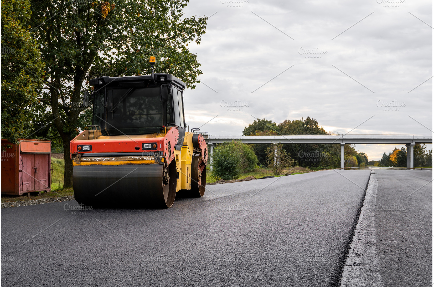 Heavy road roller compacting asphalt, an Industrial Photo by volodymyrshtun13795