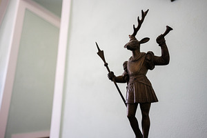 Sculpture of a deer-headed knight holding a trumpet and spear indoors, a Photo by AS photostudio
