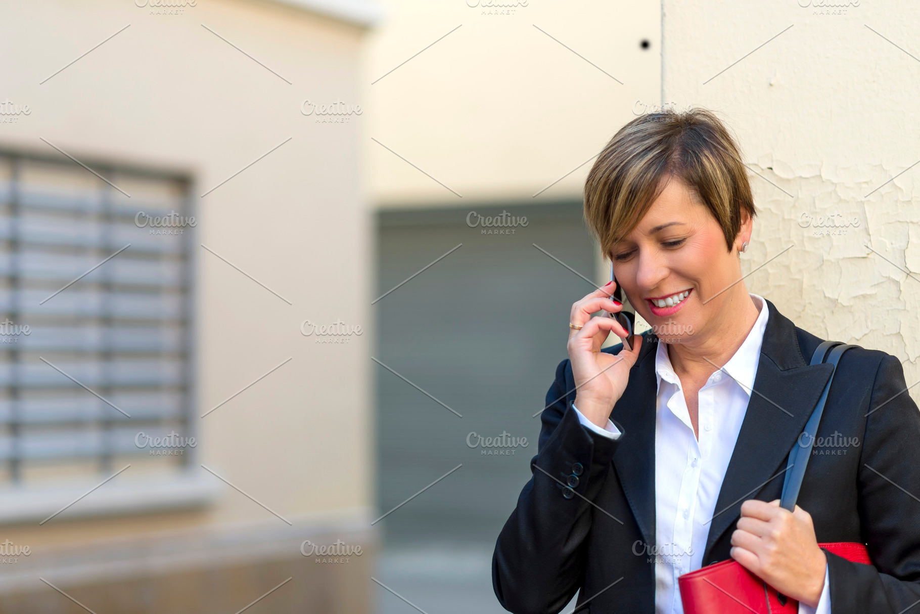 Businesswoman smiling while talking on mobile phone, a Photo by RF Images