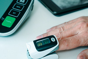 measuring oxygen saturation during a health check, a Photo by Nito