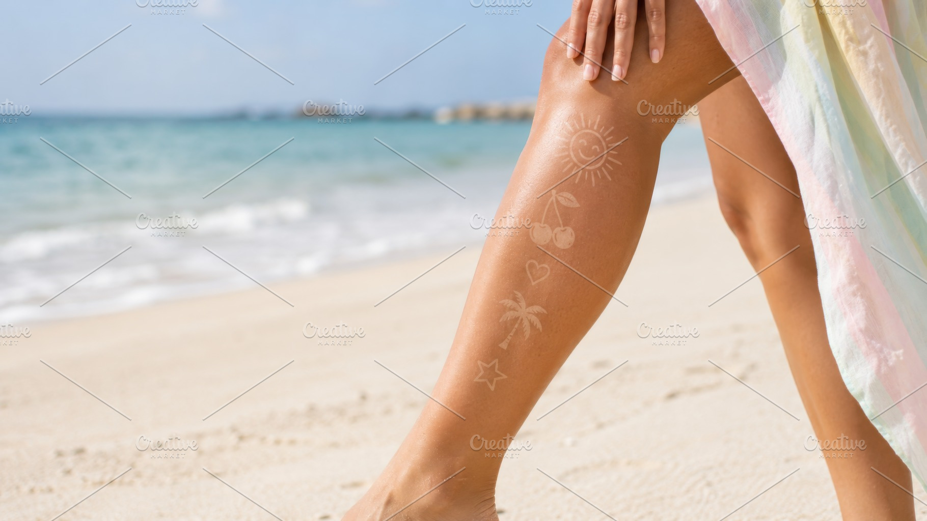 Sun tan tattoo on leg at beach with, a Photo by Dvoevnore photos