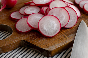 Raw Red Radish Slices on a Cutting Board, side view., a Food & Drink Photo by LiudmylaChuhunova