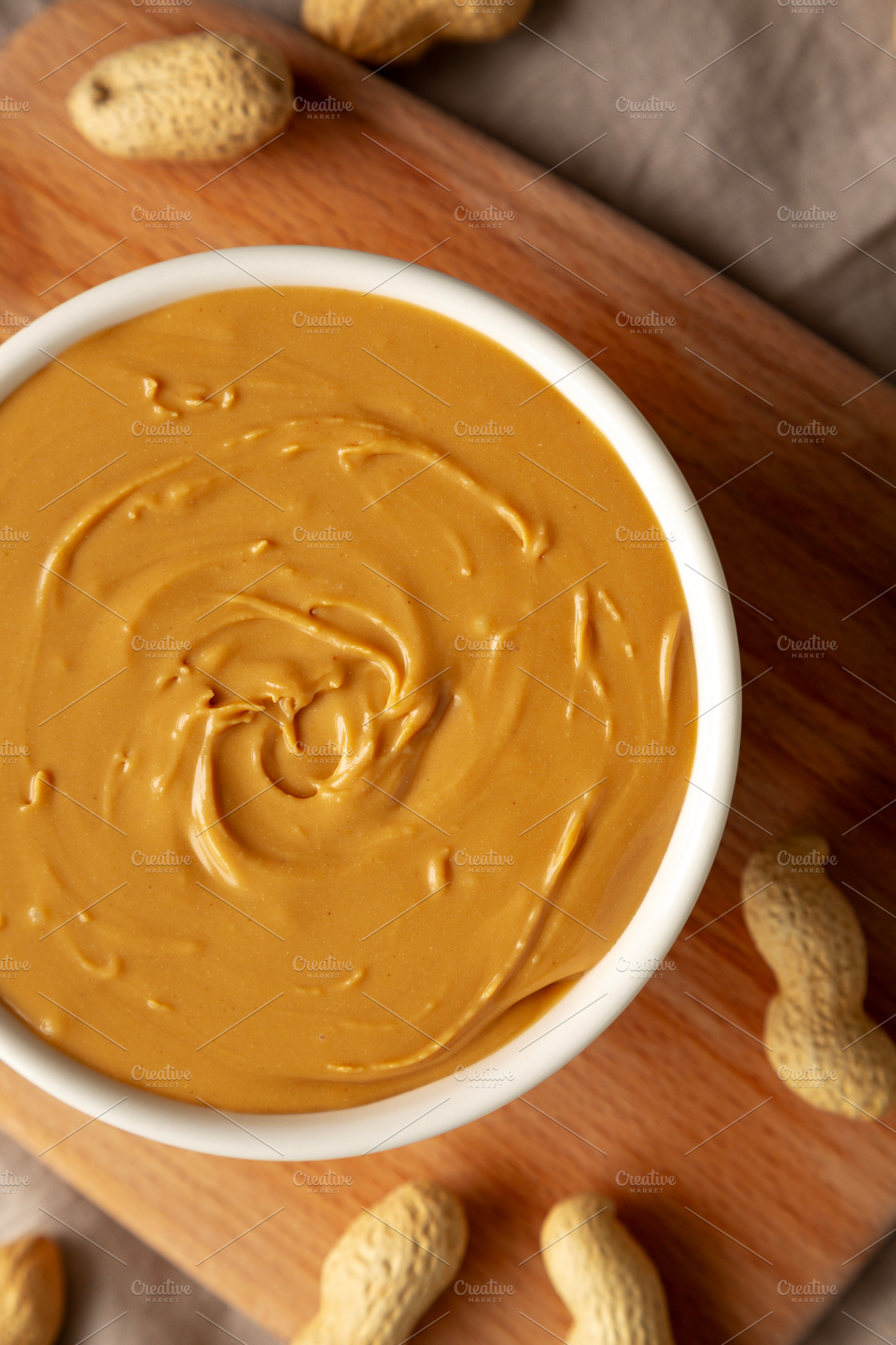 Organic Peanut Butter in a Bowl, top view. Flat lay, overhead., a Food & Drink Photo by LiudmylaChuhunova