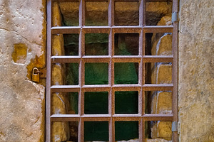 Iron cell bars on stone wall in historical site, an Architecture Photo by DanFLCreativo