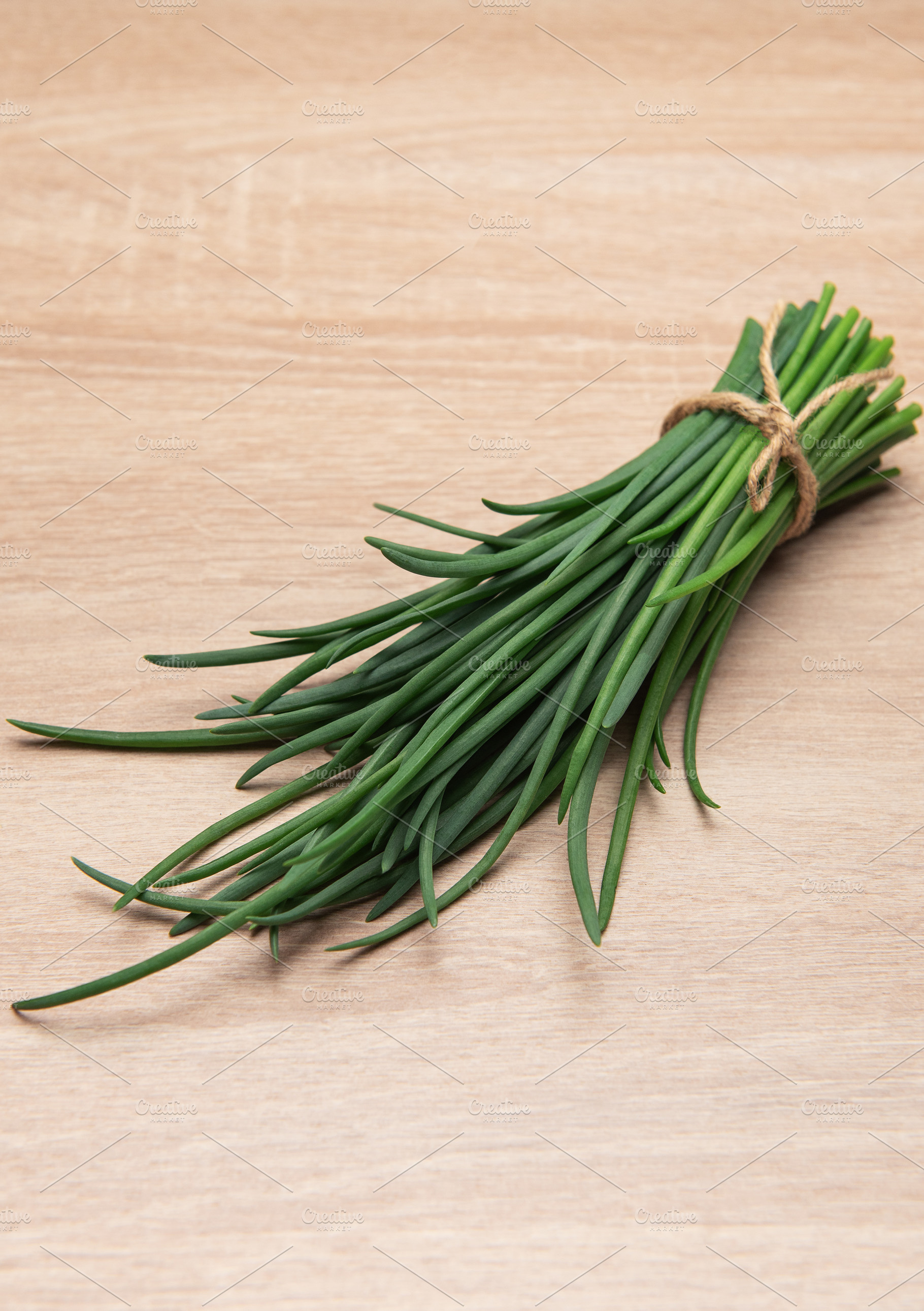 Fresh green chives tied with rustic twine, a Food & Drink Photo by Olena Rudo