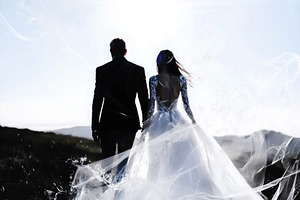 A couple holding hands, silhouetted against a bright sky. The woman wears a flo, an Arts & Entertainment Photo by Textures & Backgrounds