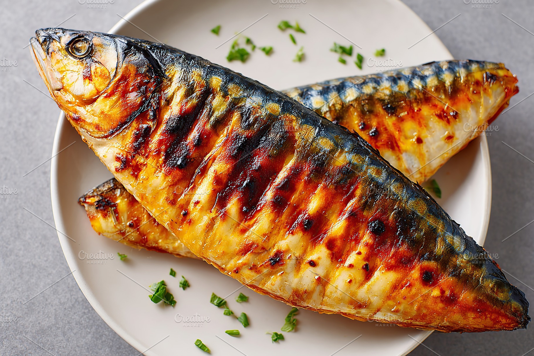 Grilled mackerel fillets served on a plate with fresh herbs and garnishes, a Food & Drink Photo by AlyaAnd