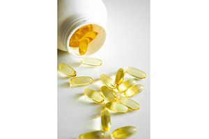 Fish oil capsules spilling from, a Health & Medical Photo by volodymyrshtun13795