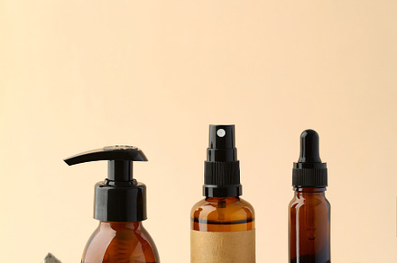 Amber glass cosmetic containers on stone podiums on beige background. Natural o, a Beauty & Fashion Photo by photoguns