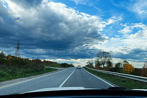 Open road ahead under dramatic blue sky with clouds, viewed from car interior, a Photo by AS photostudio