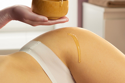 Beautician dripping honey
