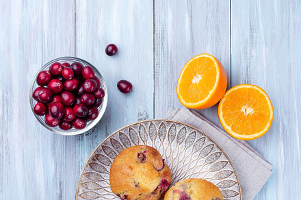 Homemade cranberry orange muffins on a wooden plate, vertical, top view, copy s, a Food & Drink Photo by iuliia_n