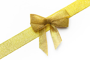 Golden glittery ribbon bow decorating a festive gift, a Photo by Olena Rudo