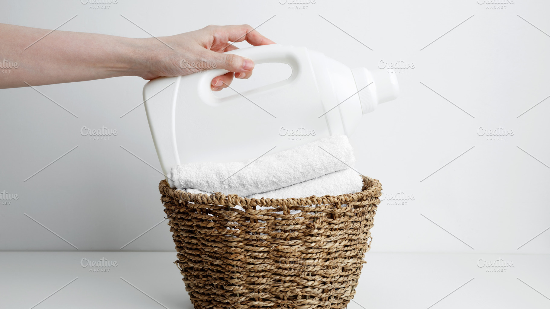 Laundry detergent branding mock up and basket filled with clean white towels. H, a Photo by matucha