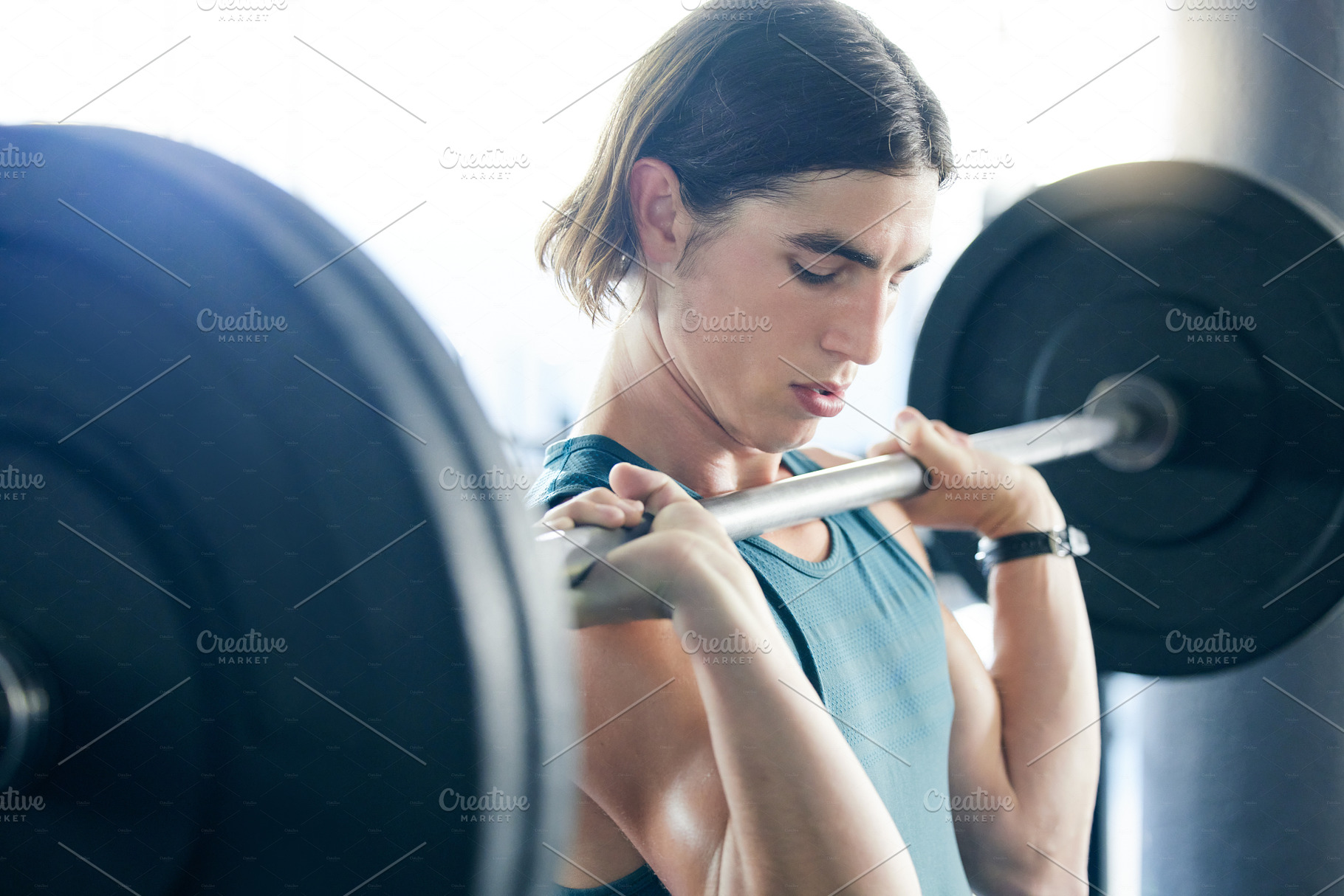 Fitness, gym and man doing barbell shoulder press exercise for strong or powerful arm muscles and bodybuilding. Bodybuilder strength training and weightlifting workout with discipline and effort, a Photo by Peopleimages.com
