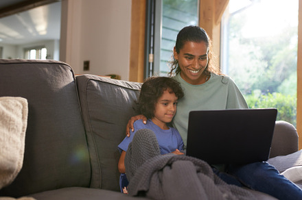 Mother and son watching movie on laptop, a Person Photo by Southworks