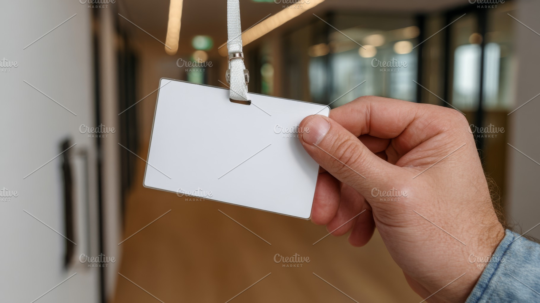 A male hand holding a blank ID badge in a modern office hallway, symbolizing id, a Business Photo by ImageMir