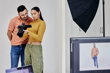 Teamwork, photographer and startup people with camera in studio set for shoot, magazine project or online content. Planning, focus or girl examine picture for digital catalog or fashion web design, a Photo by Peopleimages.com