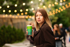 Young woman holding coffee, a Person Photo by Elena Vagengeim