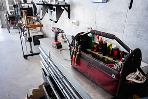 Toolbox with tools and equipment in a modern workshop on a workbench, a Photo by AS photostudio