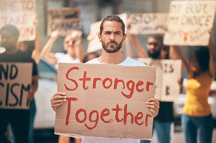 Portrait, protest in street and group stand in solidarity, climate change and march together. Man, people and crowd support human rights, equality activism and blm movement for lgbtq, racism or earth, a Photo by Peopleimages.com
