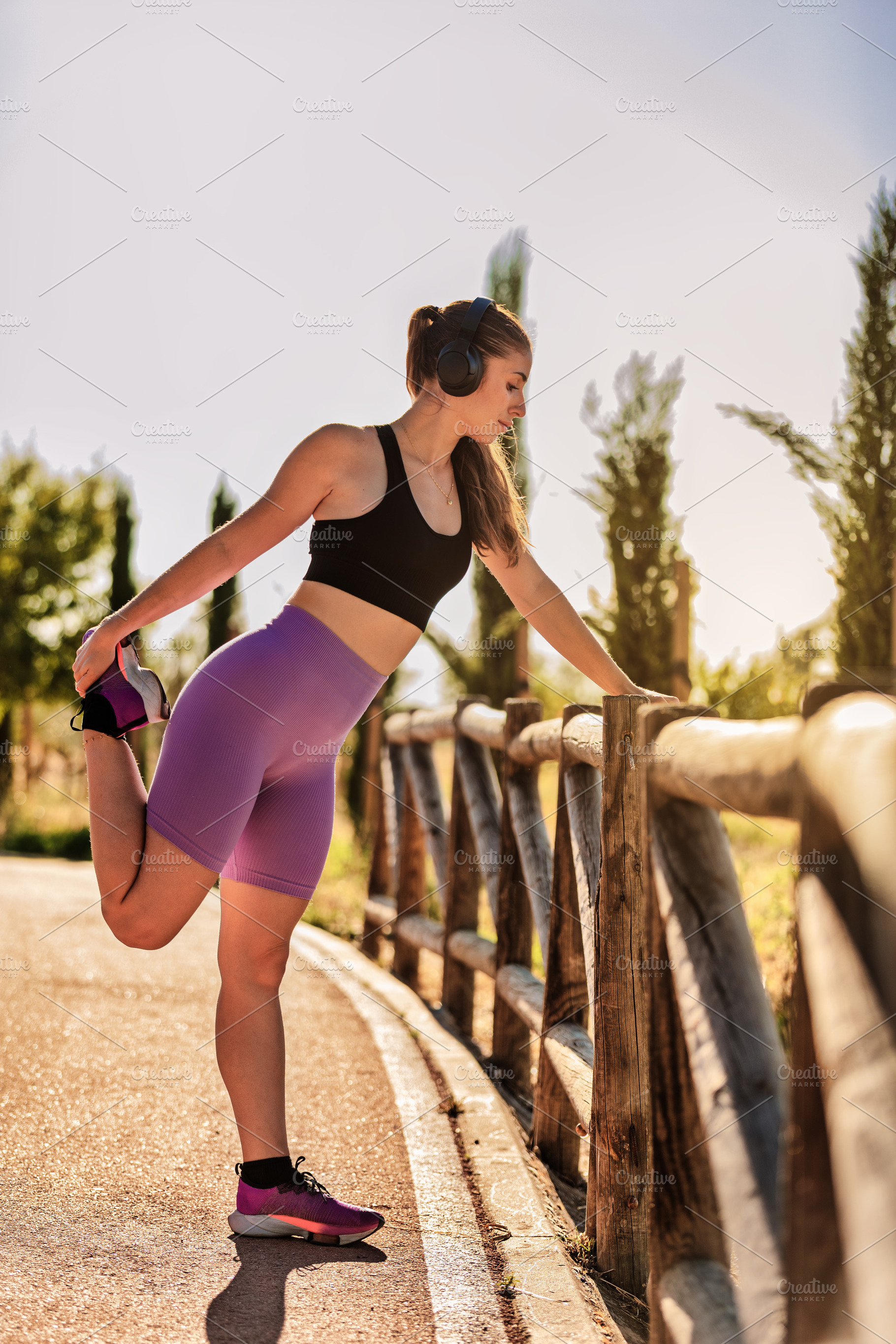 Young woman stretching her leg with, a Sports & Recreation Photo by Perpis