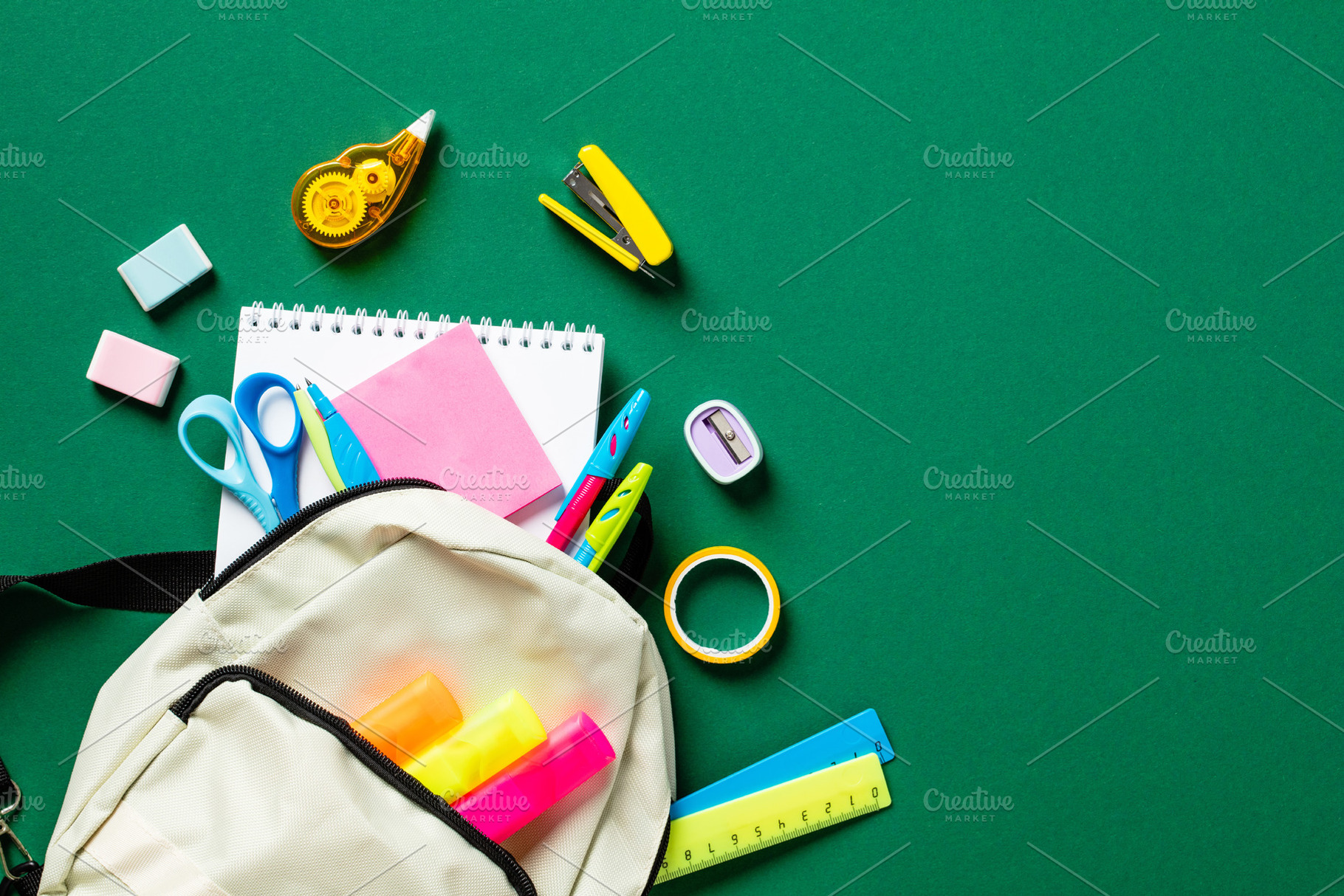 School backpack with colorful stationery on green table. Back to school concept, a School & Education Photo by photoguns