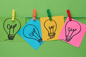 Multicolored stickers with pictures of light bulbs are fastened, a Business Photo by ndanko