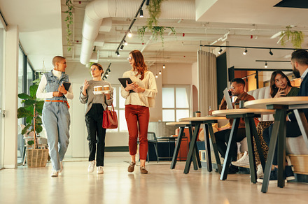 Group of businesswomen walking through a modern office, a Person Photo by Jacob Lund