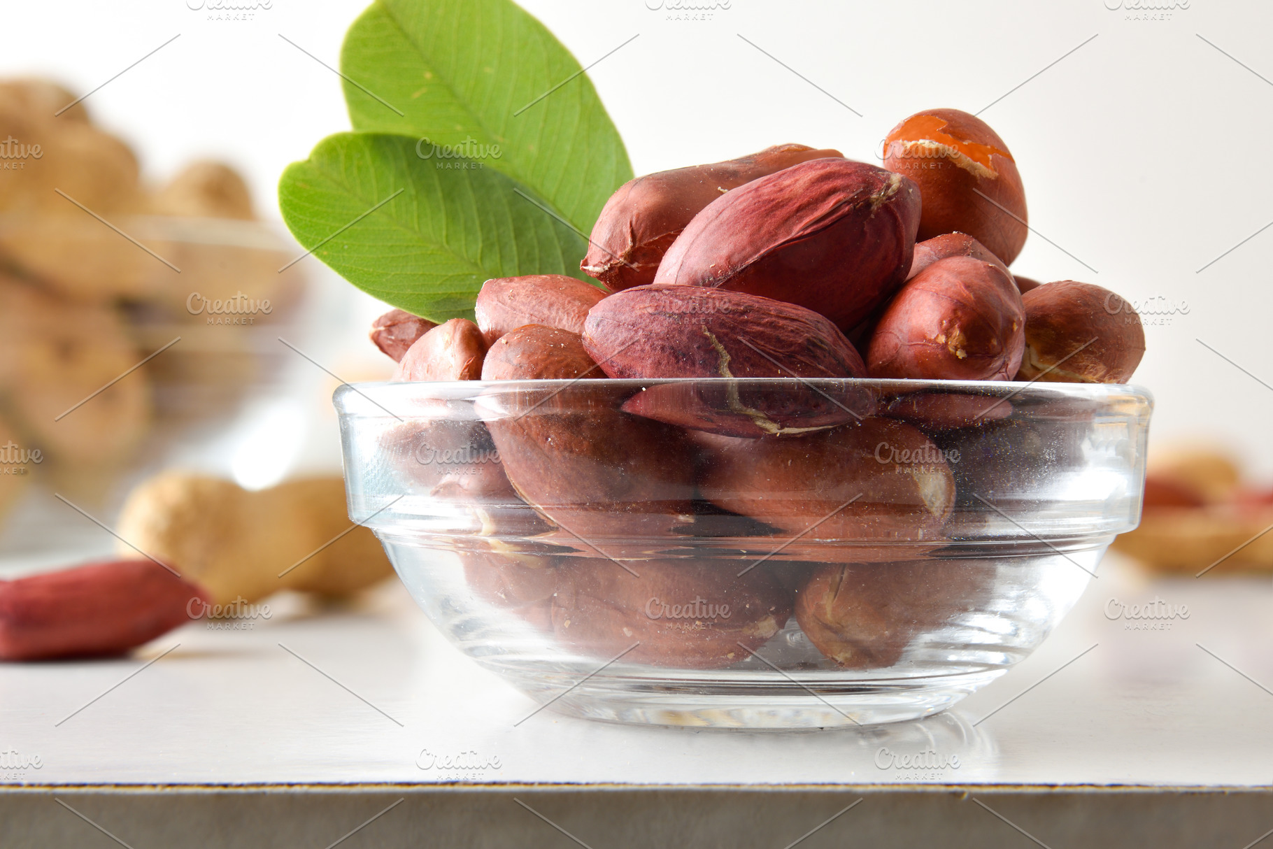 Detail of peeled peanuts in glass bowl on a white table, a Food & Drink Photo by Davizro's Market