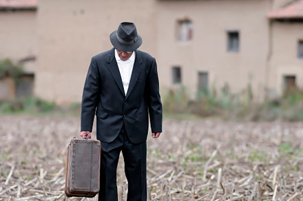 emigrant with suitcase and vintage suit leaving his village to l