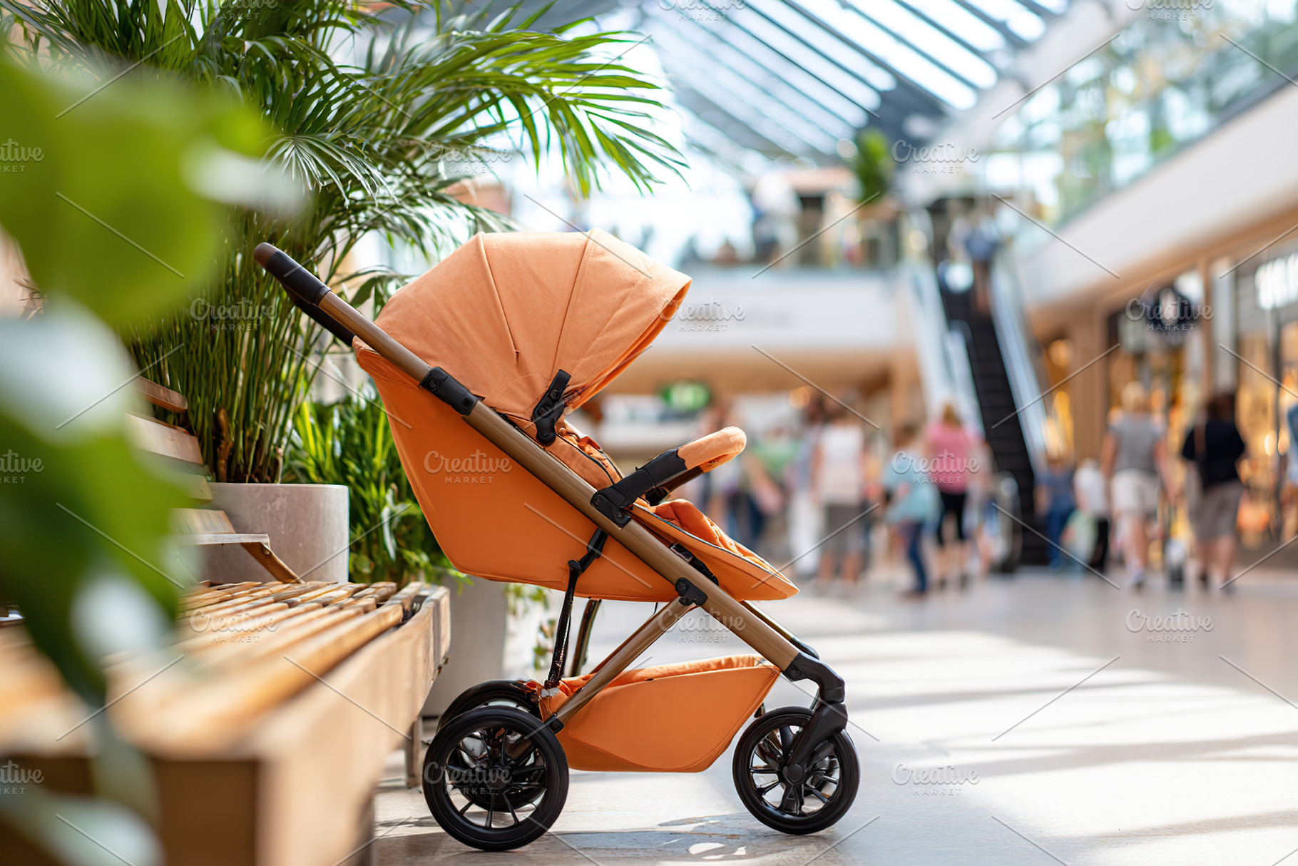 Stroller parked in a busy shopping mall filled with families and shoppers enjoy, a Photo by AlyaAnd