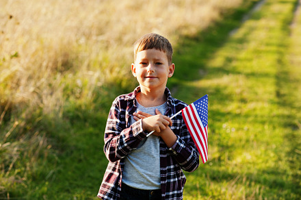Little boy with USA flag outdoor. America celebrating. Hand on h, a Person Photo by AS photostudio