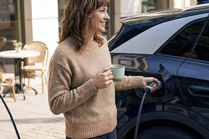 Woman plugging in her electric car, a Person Photo by Shootdiem