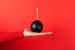 A hand in a red sleeve holds a black cartoon-style bomb with a f, a Technology Photo by Ales Munt