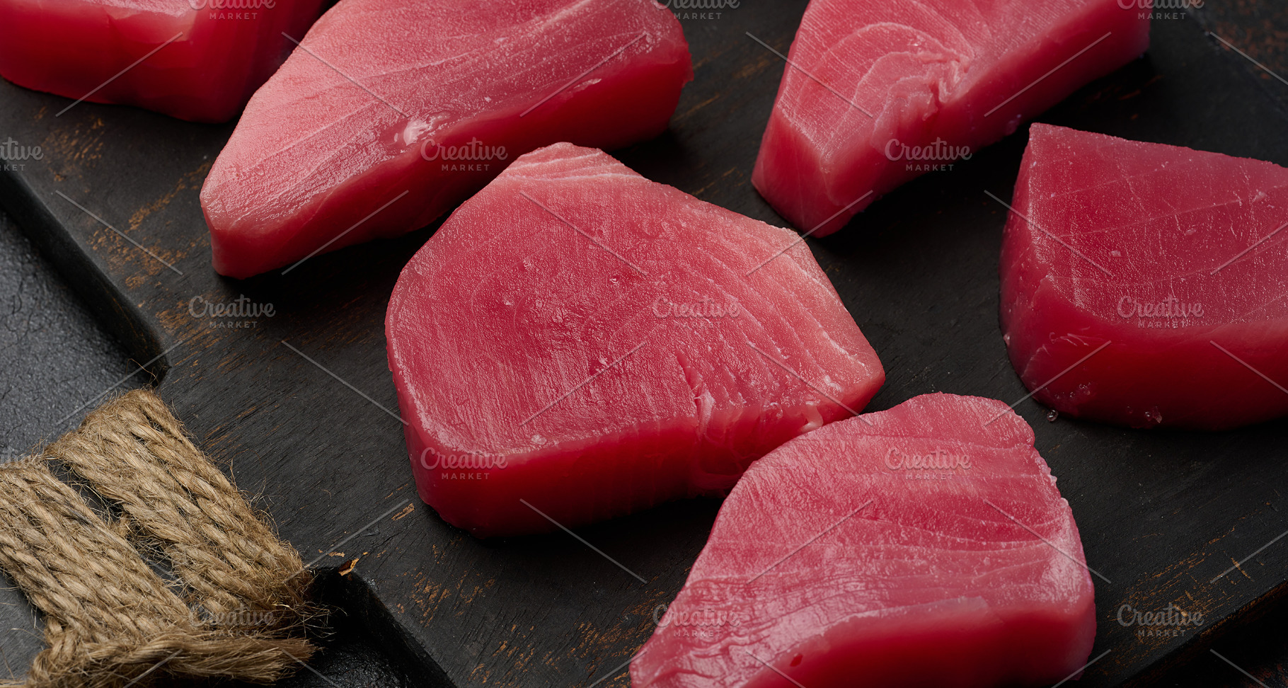 Raw tuna pieces on a wooden board, top view, a Food & Drink Photo by ndanko