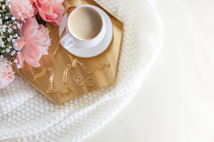 White cup of coffee and decorations on a golden tray in the nord