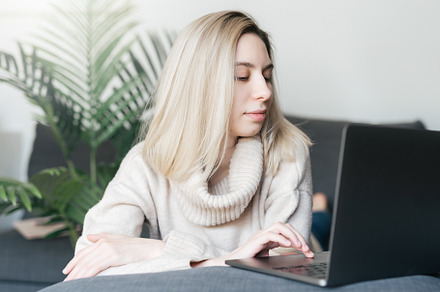 Young woman working on laptop in  home, a Person Photo by Olena Rudo