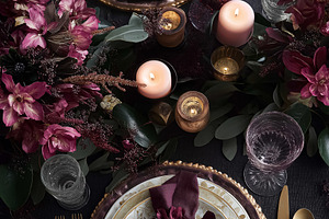 Dining table arrangement with decorative plates, napkins, flowers, and candleli, a Food & Drink Photo by Studio ANNA