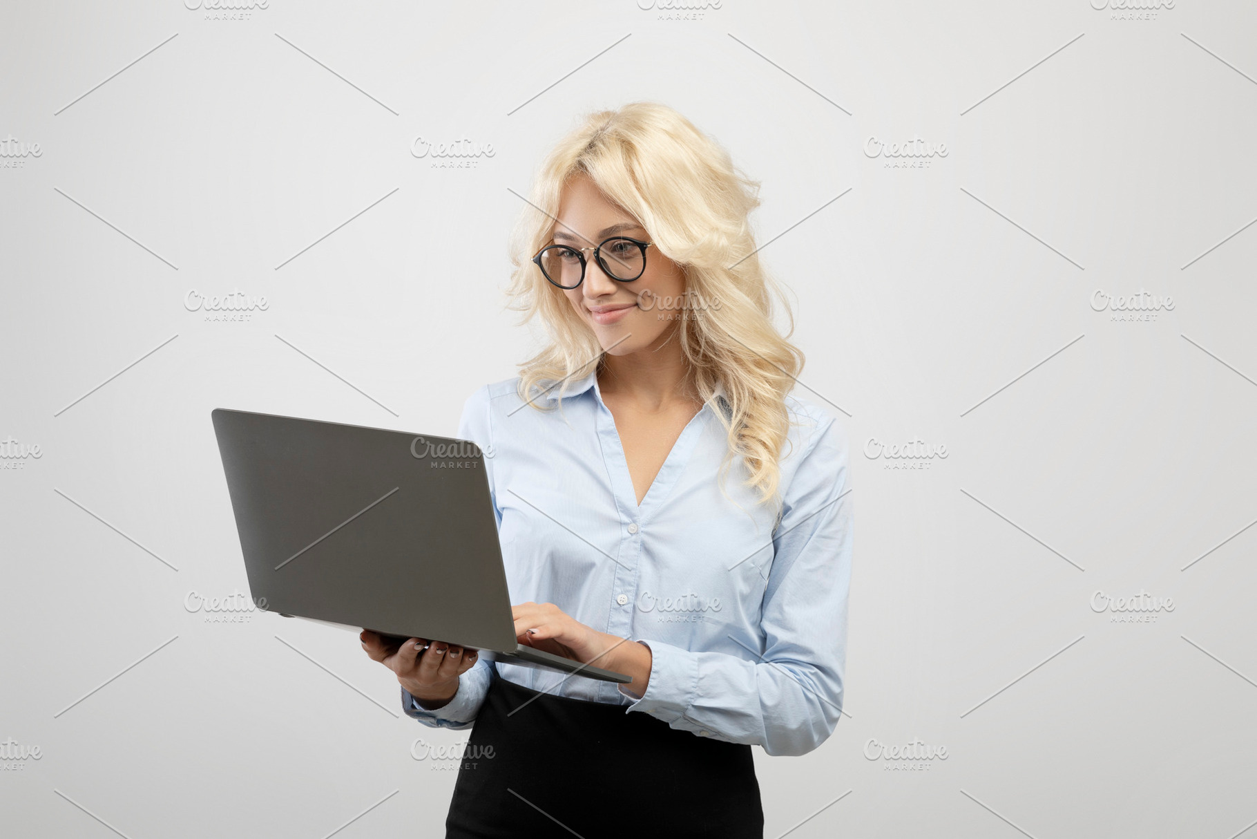 Successful businesswoman in formal wear using laptop computer over light grey s, a Photo by Prostock-Studio