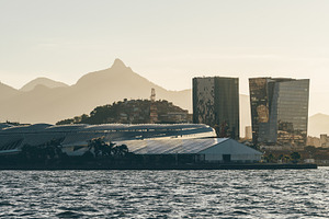 Sunlit skyline by coastal water, an Architecture Photo by SkyNext