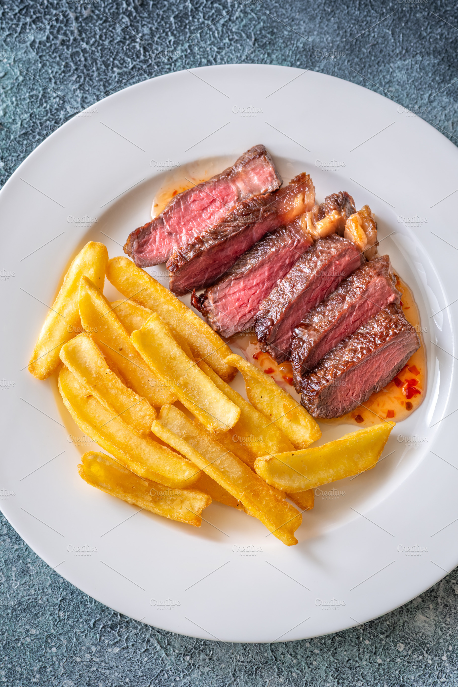 Sliced grilled beef steak with fries, a Food & Drink Photo by Alexander Prokopenko