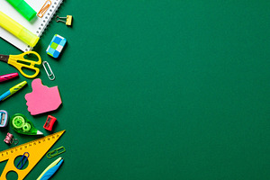 Back to school concept. Flat lay colorful school stationery on green background