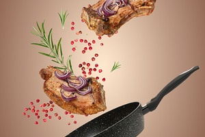 A levitating arrangement of two grilled pork steaks with red oni, a Food & Drink Photo by ndanko