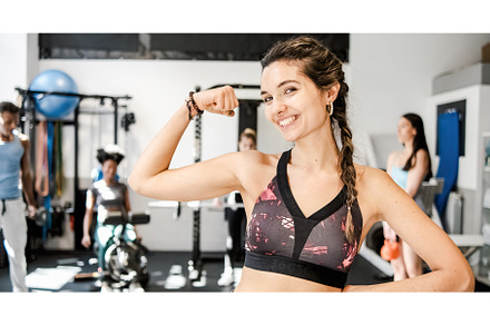 Cheerful woman showing bicep in, a Sports & Recreation Photo by Daniel Megias