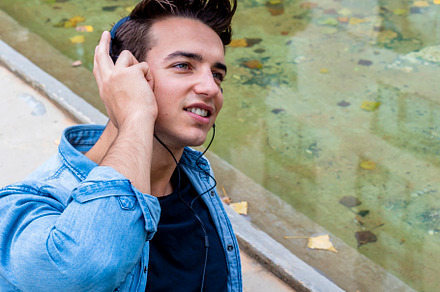 Man listening to music by a pond., a Person Photo by RF Images