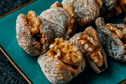 dried figs filled with walnuts on a plate, a Photo by Nito